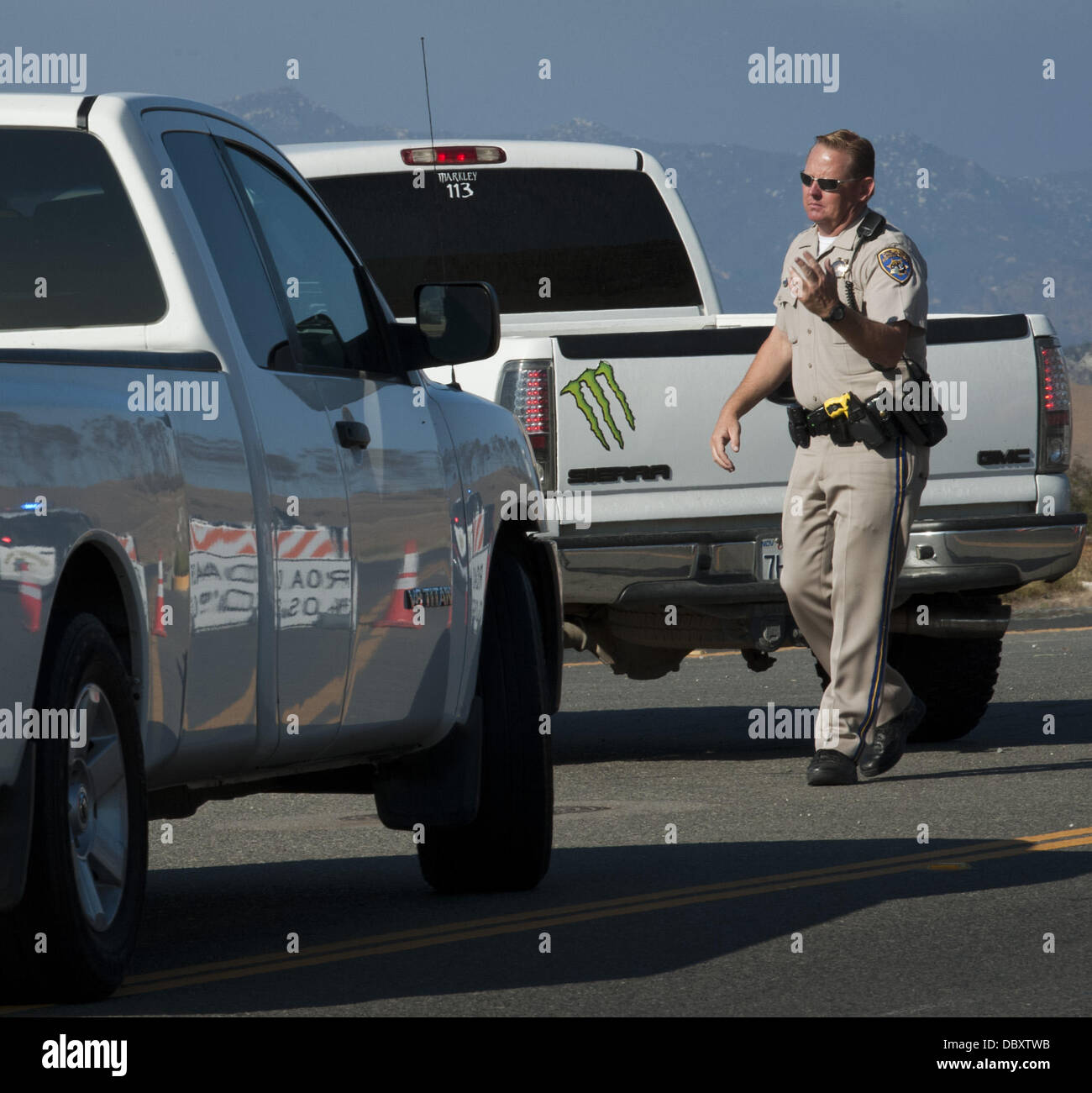 El Cariso, Californie, USA. 5 Août, 2013. La California Highway Patrol Officer arrête la circulation sur l'autoroute Ortega et Antonio Parkway, le lundi après-midi.db.jpg---8/5/13 -- PHOTO DE DAVID BRO/Zuma Press--- les équipes de pompiers ont répondu à un incendie de forêt et de broussailles dans la forêt nationale de Cleveland dans le Comté de Riverside tôt le lundi matin. Crédit : David Bro/ZUMAPRESS.com/Alamy Live News Banque D'Images