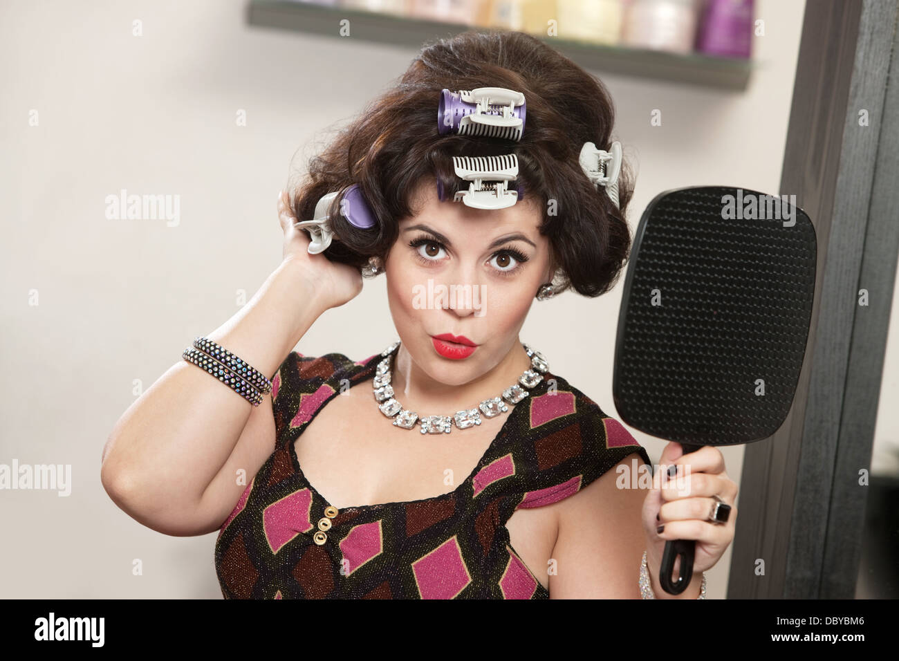 Woman in Curlers Holding Mirror Banque D'Images