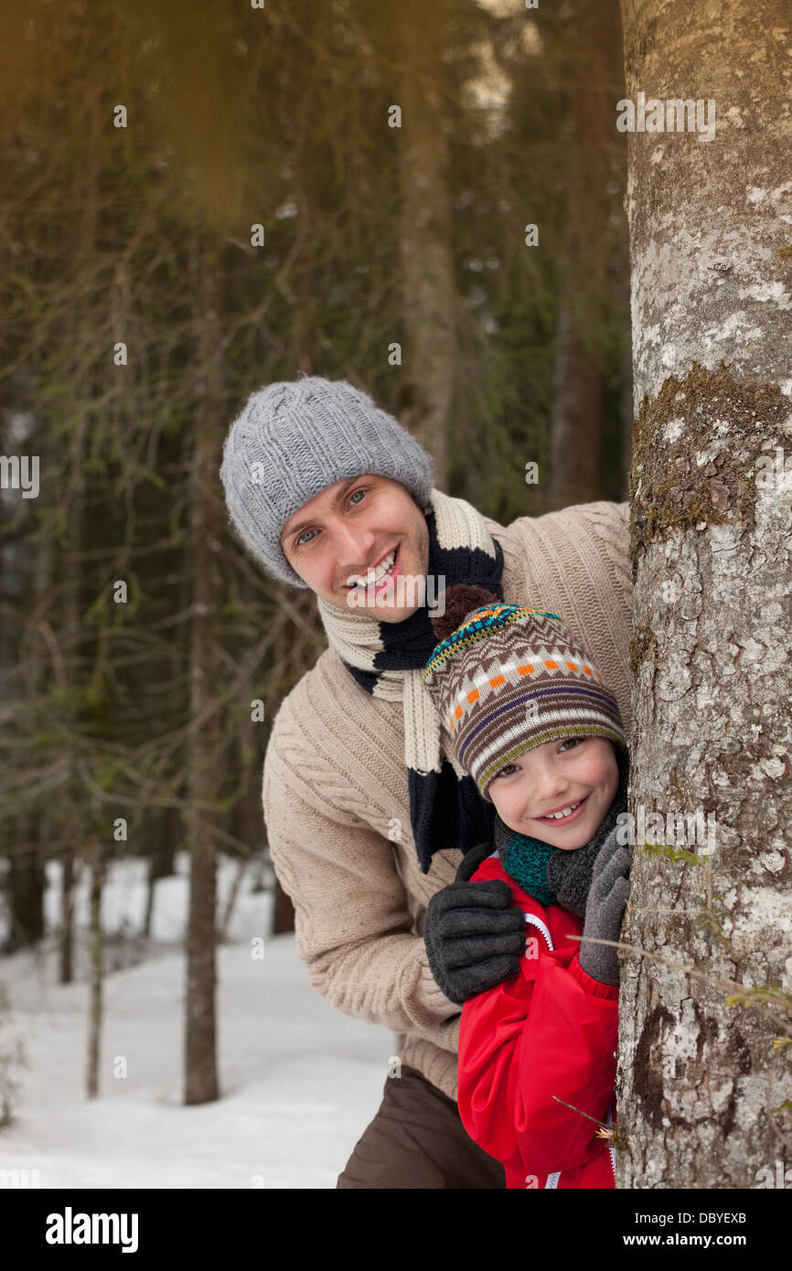 Portrait of happy father and son tronc d'arbre derrière in Snowy Woods Banque D'Images