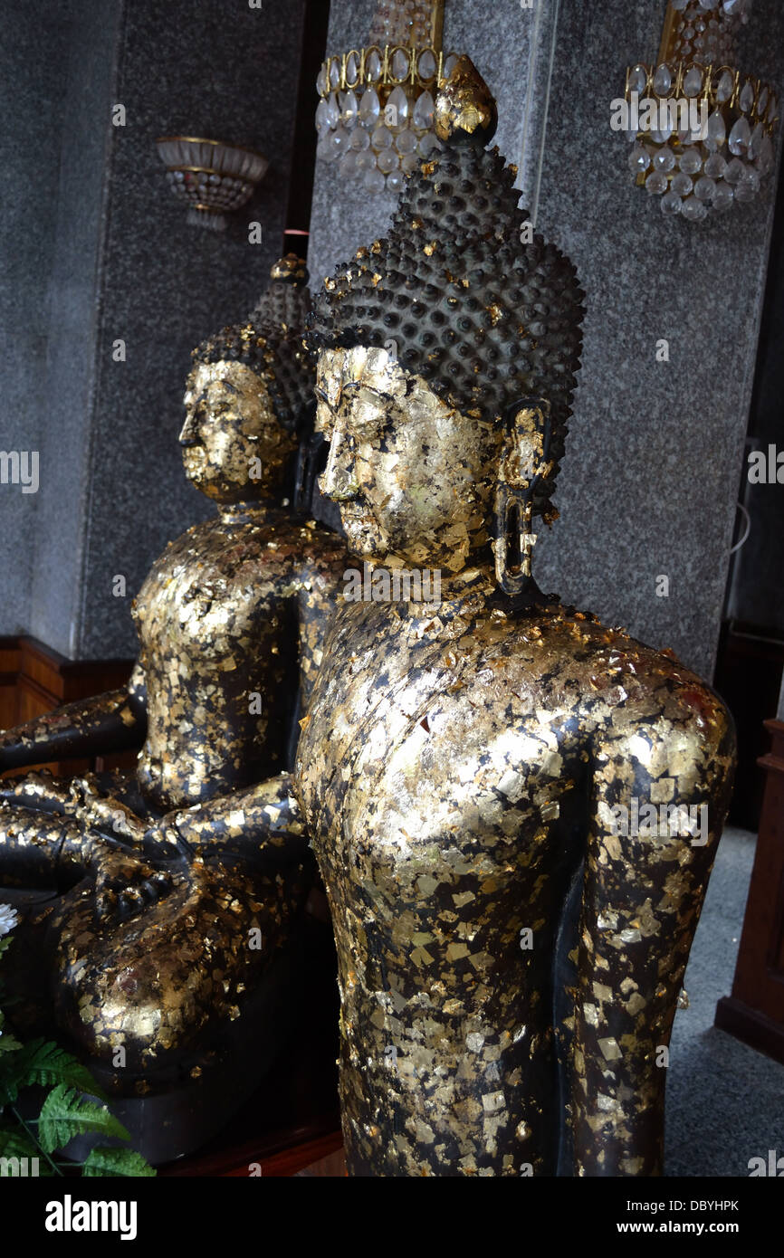 Statue de Bouddha recouverte de feuilles d'or offerts par les thaïlandais. Banque D'Images