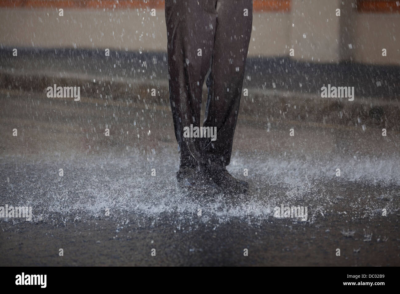 Businessman standing in rainy street Banque D'Images