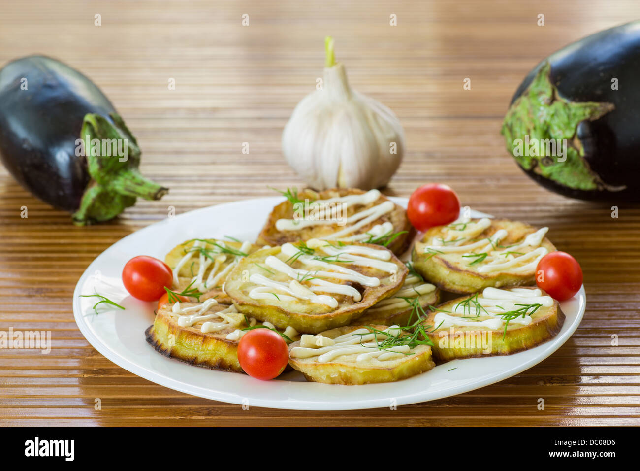 Aubergines frites avec de la mayonnaise et l'ail sur une plaque Banque D'Images