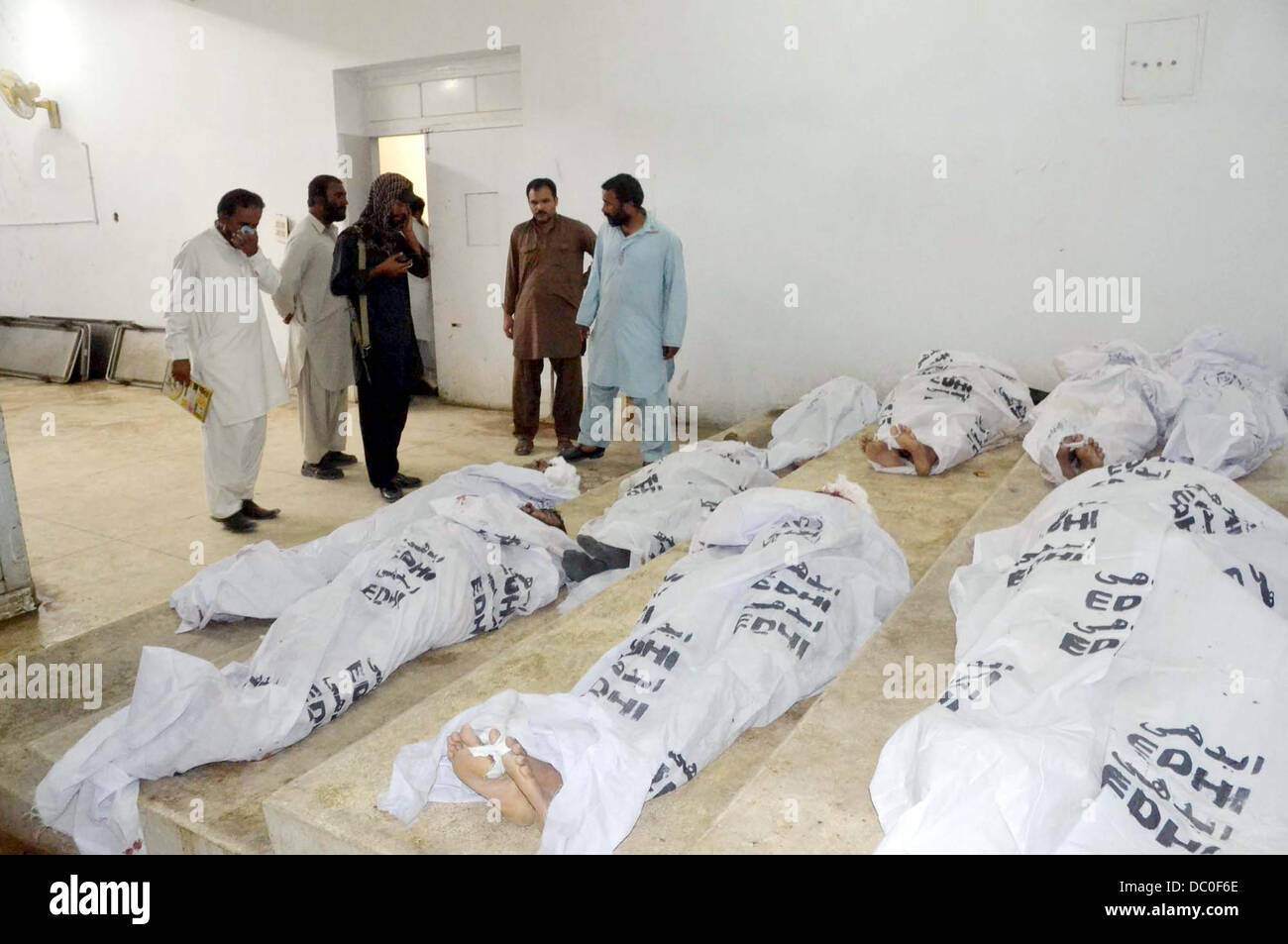 Les gens se rassemblent près de cadavres de passagers, qui a tué des inconnus armés à Giyani Pul près de Mach dans la zone du District de Bolan, à l'hôpital local de Quetta. Au moins treize personnes ont été tuées après leur enlèvement du Punjab, autobus à Giyani Pul près de Mach dans la zone du District de Bolan. Selon la police, les mécréants kidnappé 22 passagers la nuit dernière de cinq bus allant à et de Rajanpur Sadiqabad de Quetta. Il semble avoir surtout ciblé les gens de la province centrale du Pendjab avant de Eid-ul-Fitar. Banque D'Images