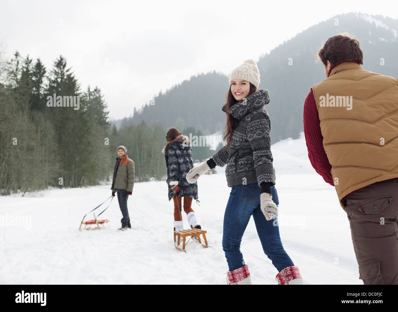 Les amis de tirer des traîneaux in snowy field Banque D'Images