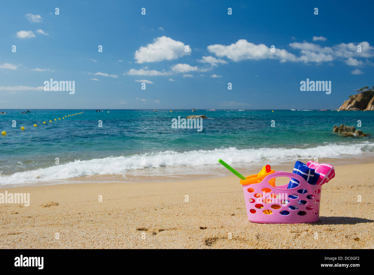 Sac de plage rose dans le sable près de la ligne d'eau à la plage d'Espagnol Banque D'Images