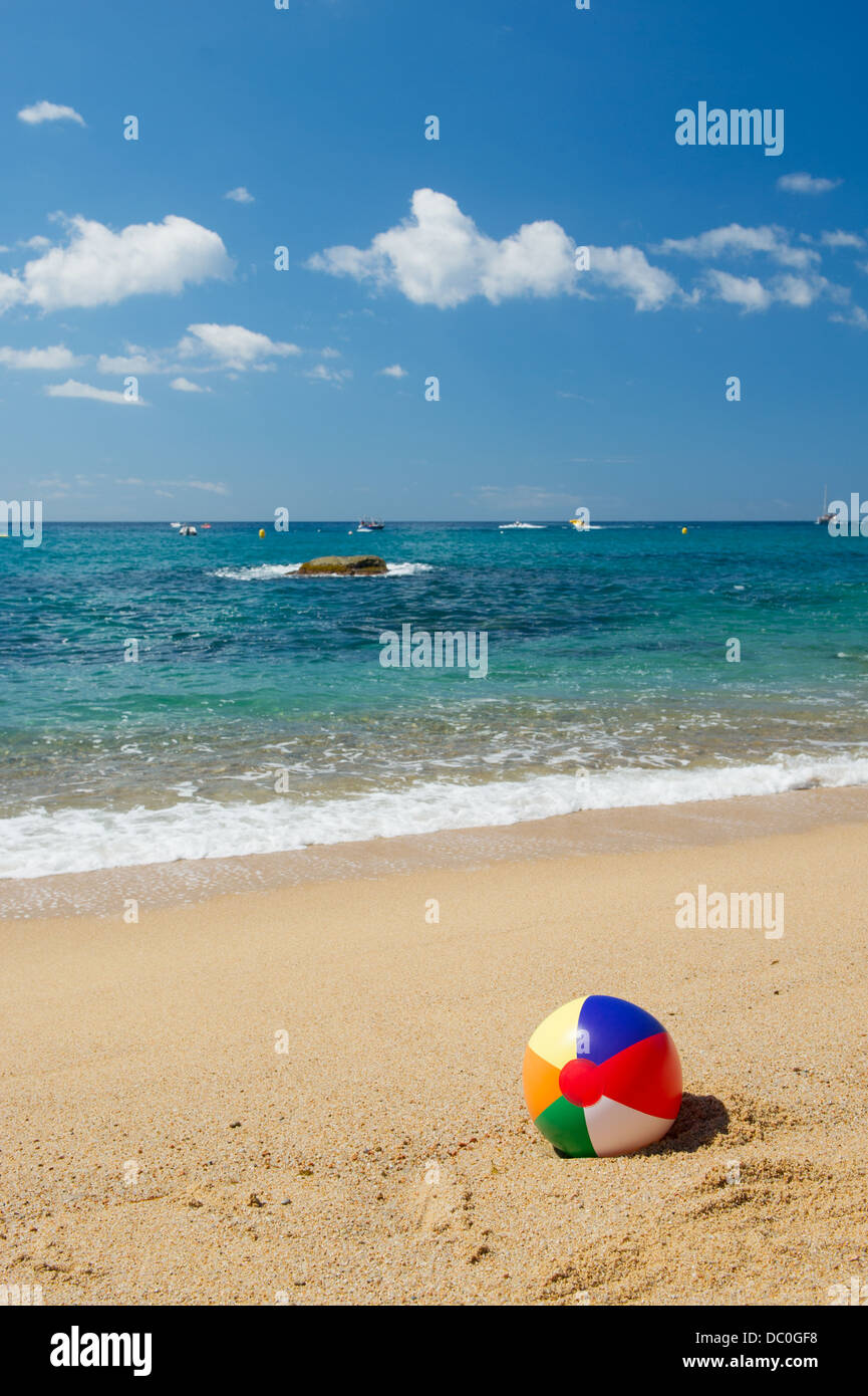 Ballon de plage gonflable dans le sable près de la ligne d'eau à la plage d'Espagnol Banque D'Images