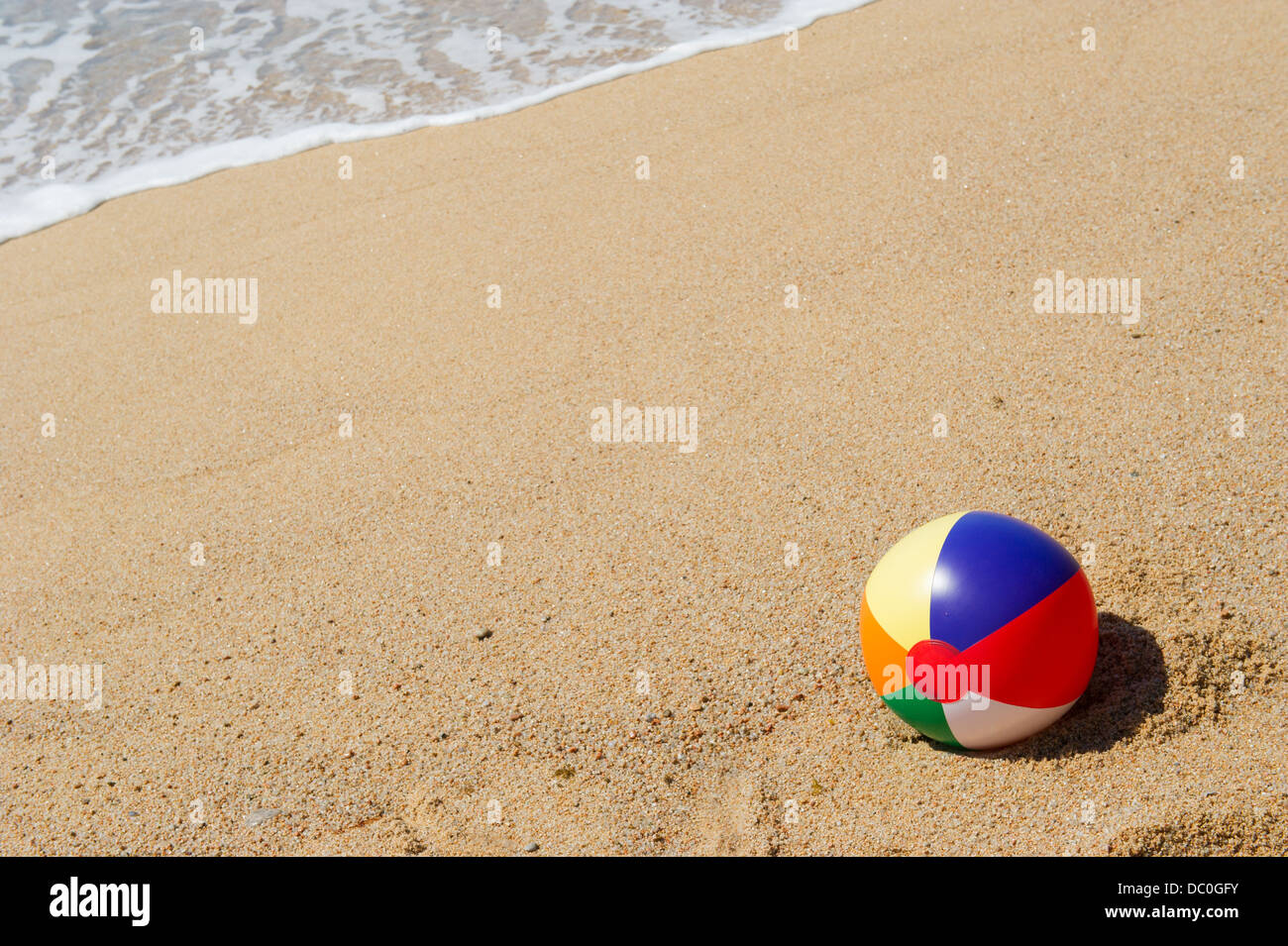 Ballon de plage gonflable dans le sable près de la ligne d'eau Banque D'Images
