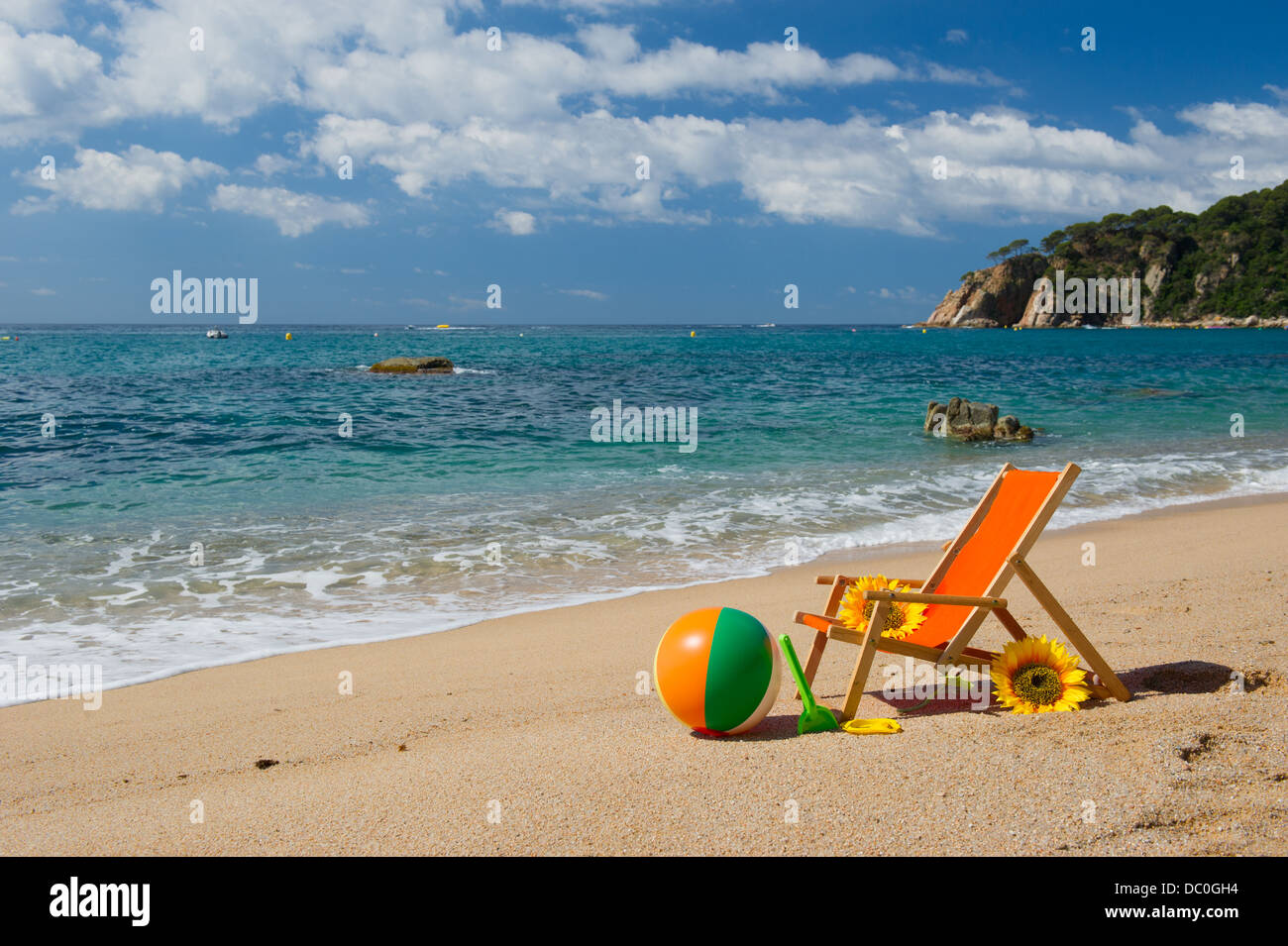 Chaise de plage vide avec des fleurs et des jouets à la mer Banque D'Images