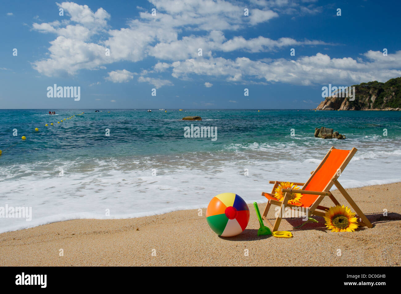 Chaise de plage vide avec des fleurs et des jouets à la mer Banque D'Images