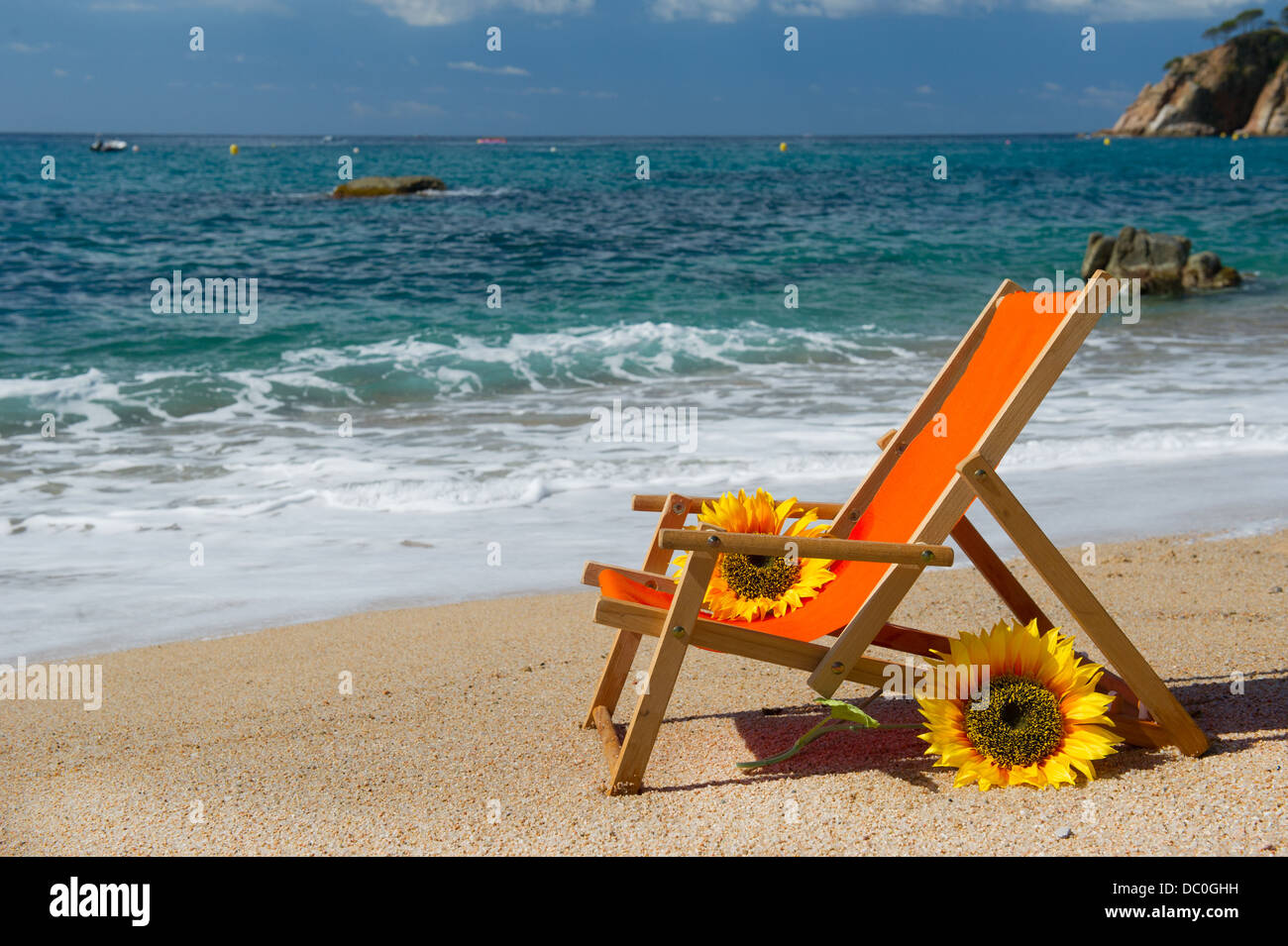 Chaise de plage vide avec des fleurs et des jouets à la mer Banque D'Images