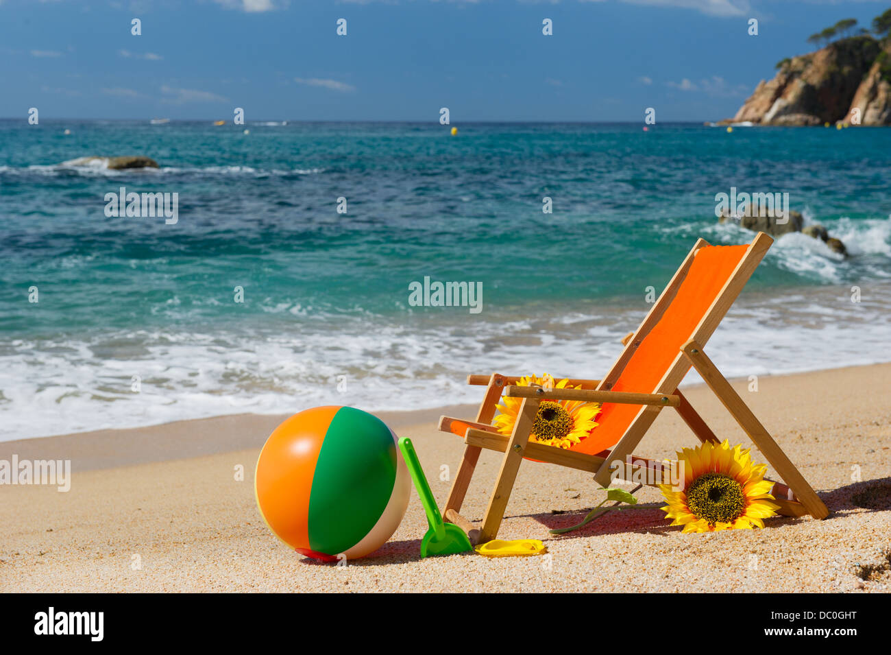 Chaise de plage vide avec des fleurs et des jouets à la mer Banque D'Images