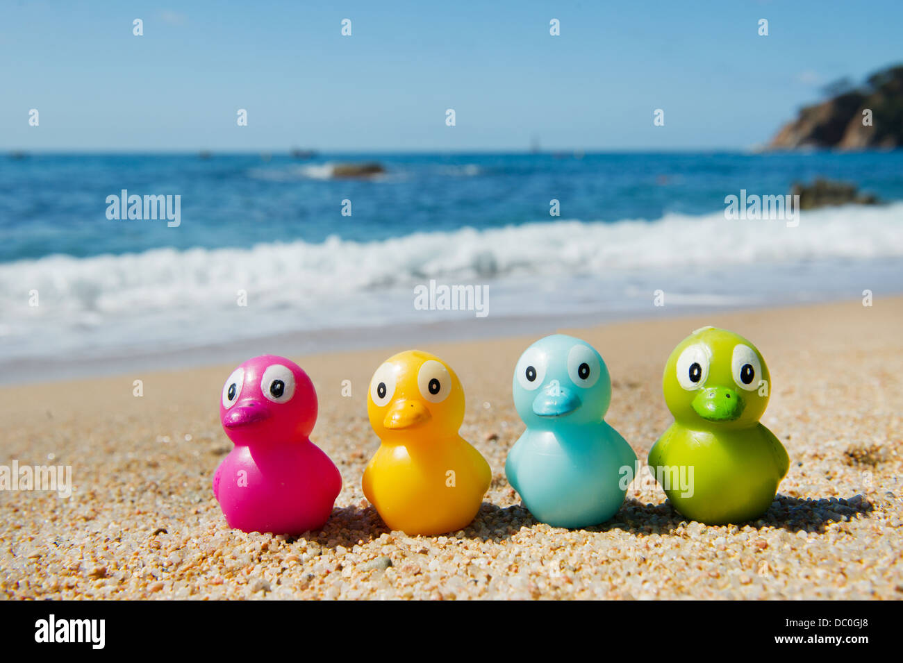 Jouet coloré canards dans le sable à la plage Banque D'Images