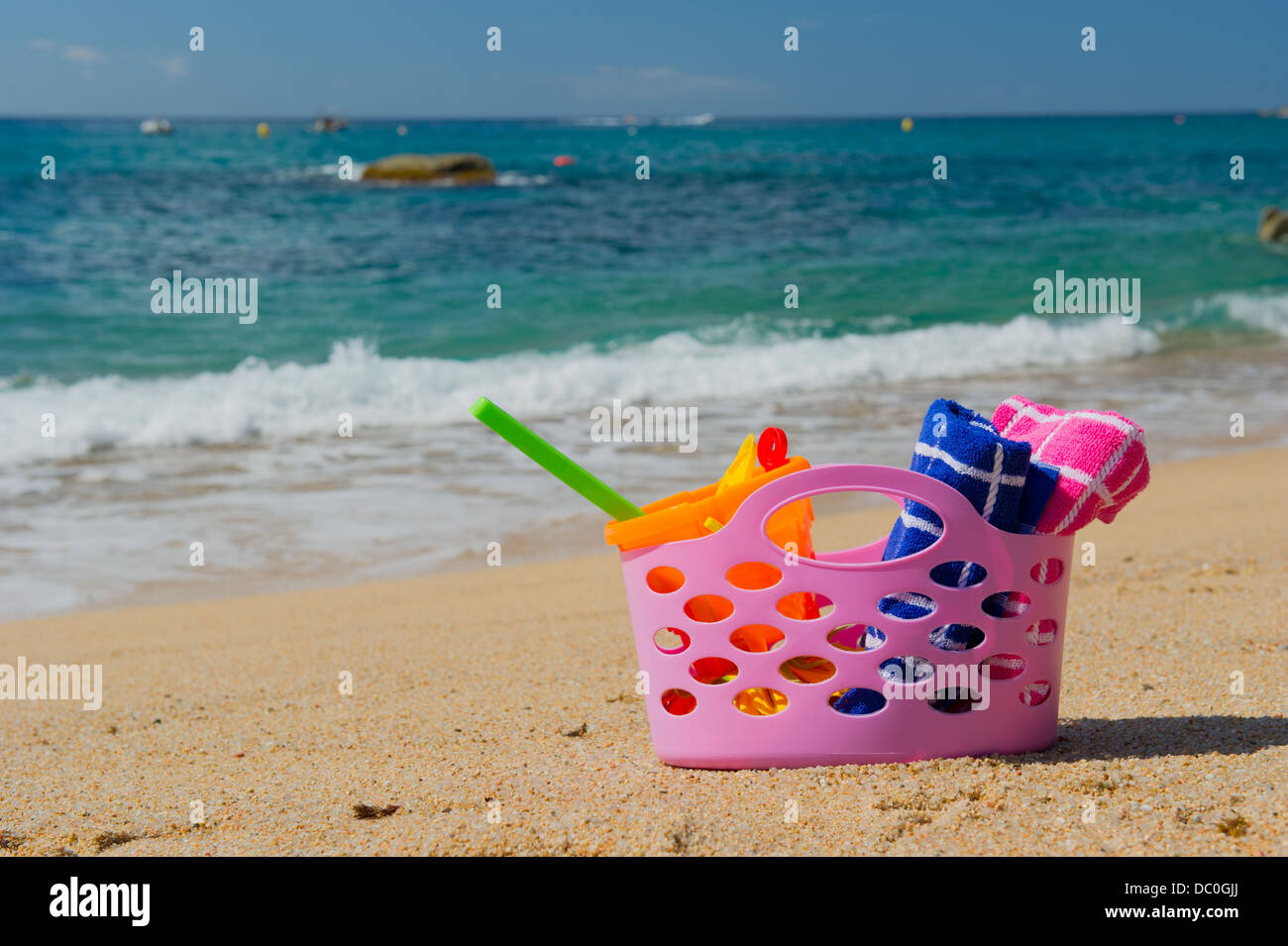 Sac de plage rose dans le sable près de la ligne d'eau à la plage d'Espagnol Banque D'Images
