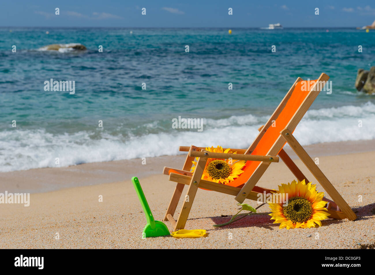 Chaise de plage vide avec des fleurs et des jouets à la mer Banque D'Images