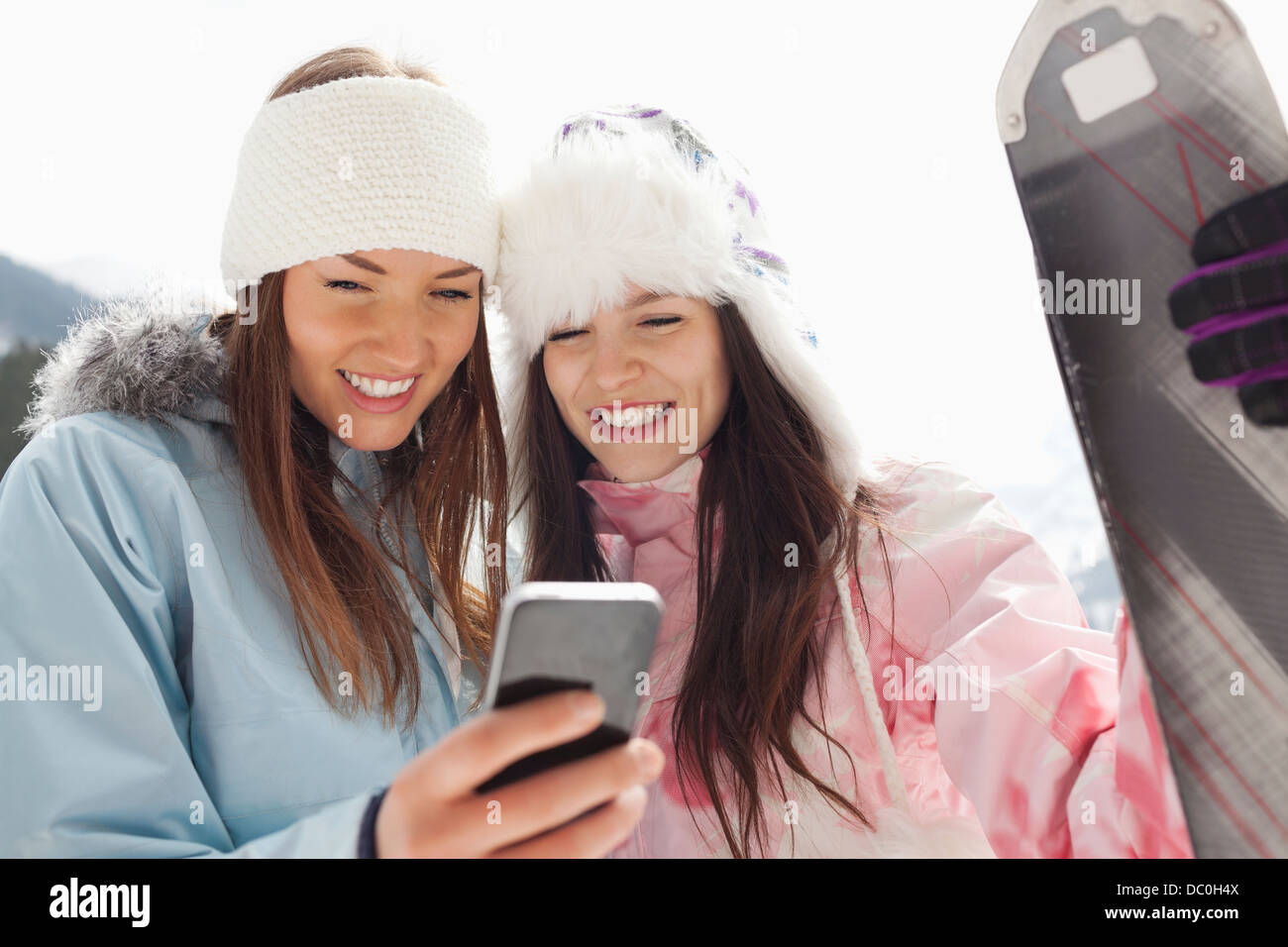 Les femmes avec des skis à la messagerie texte avec cell phone Banque D'Images