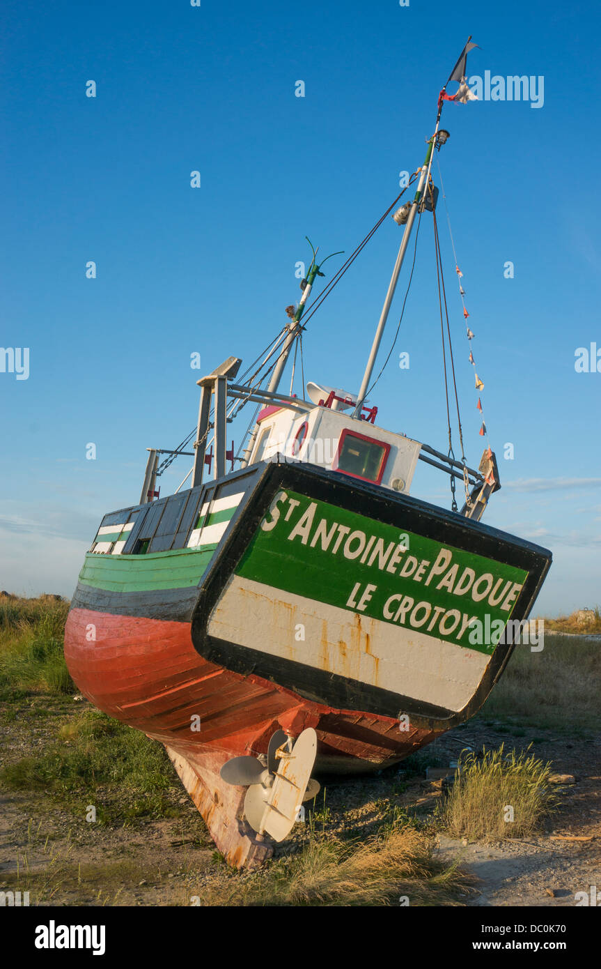 Bateau en bois sur une terre sèche, contre un ciel bleu clair, dans la ville côtière du Crotoy, située dans le département du Nord, France, Europe. Banque D'Images