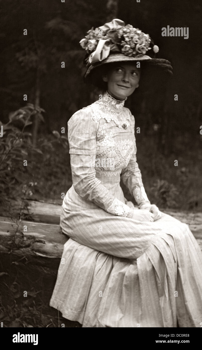 1900s 1910s TOUR DE SIÈCLE ANONYME DE BEAUTÉ FEMME EN ROBE BLANCHE GRAND CHAPEAU FLEURS RUBANS SOURIRE SUBTIL MICHIGAN USA Banque D'Images