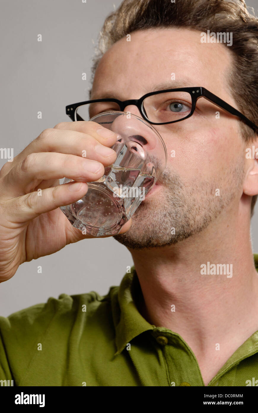 Un homme boit un verre d'eau Banque D'Images