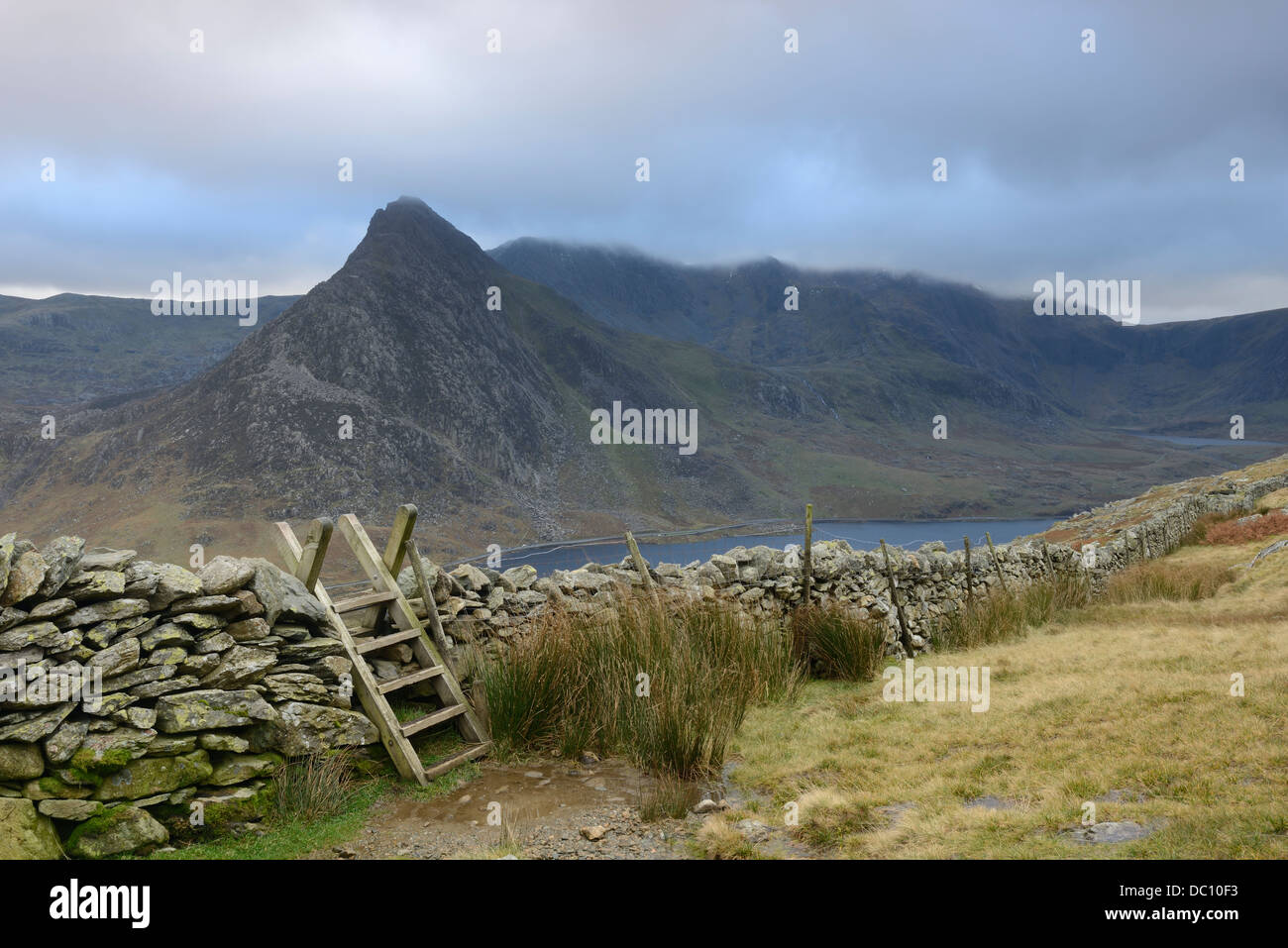 Un mur de pierres sèches de passage en bois stile donnant sur la montagne et Glyderau Tryfan gamme en Galles. Banque D'Images