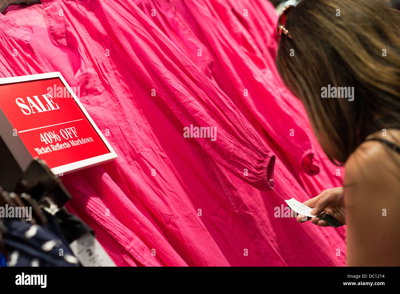 Femme la chasse aux aubaines dans un magasin de vêtements. Banque D'Images