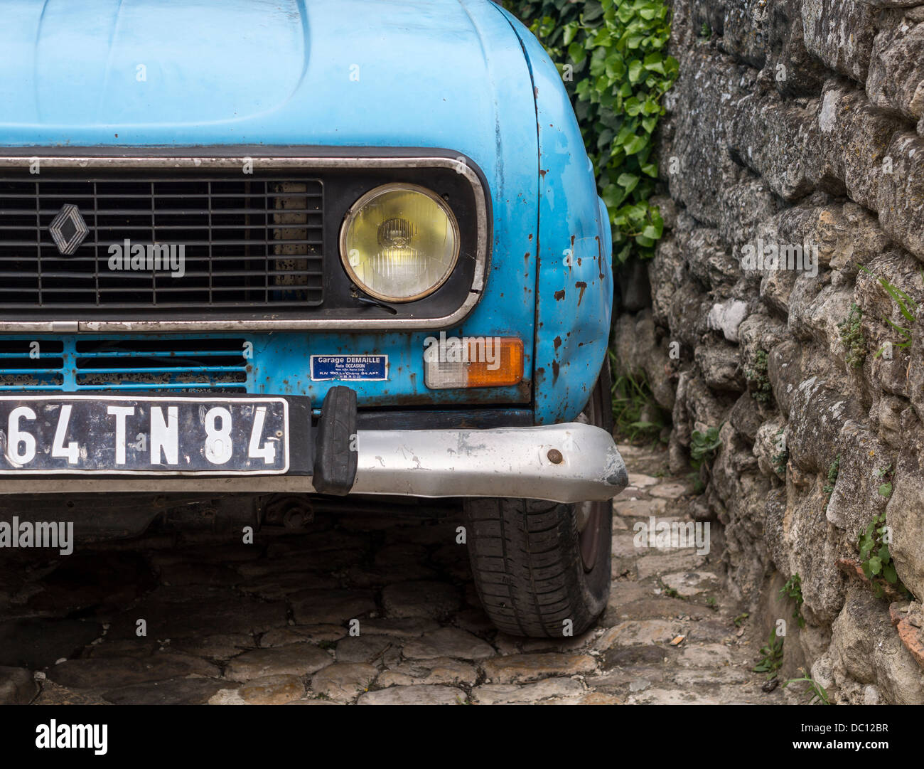 Vieille voiture citron bleu vif. Détail de l'angle d'une automobile garée plutôt vieux à côté d'un mur de pierre. Banque D'Images