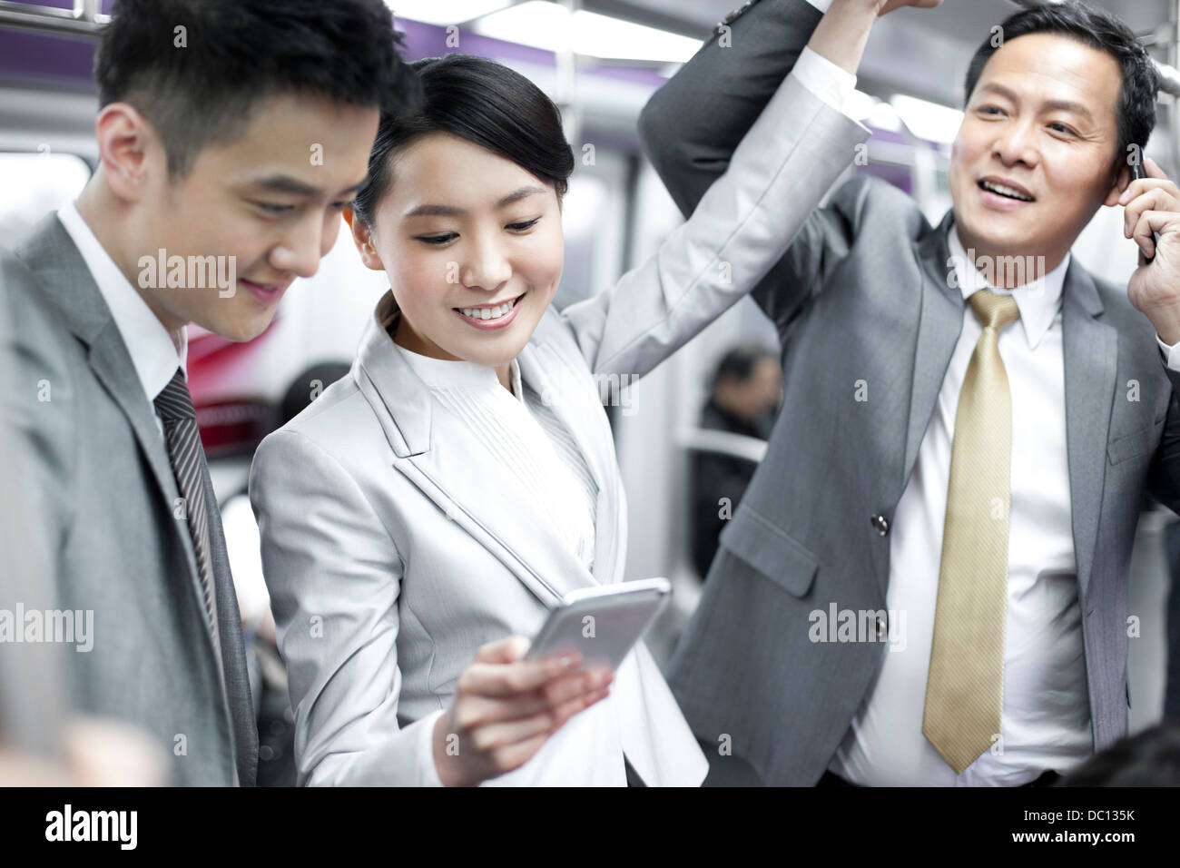 Les personnes gaies avec téléphone mobile dans Subway train Banque D'Images
