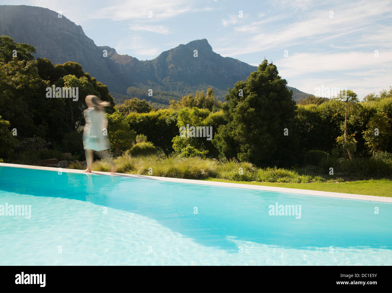 Woman walking along piscine Banque D'Images