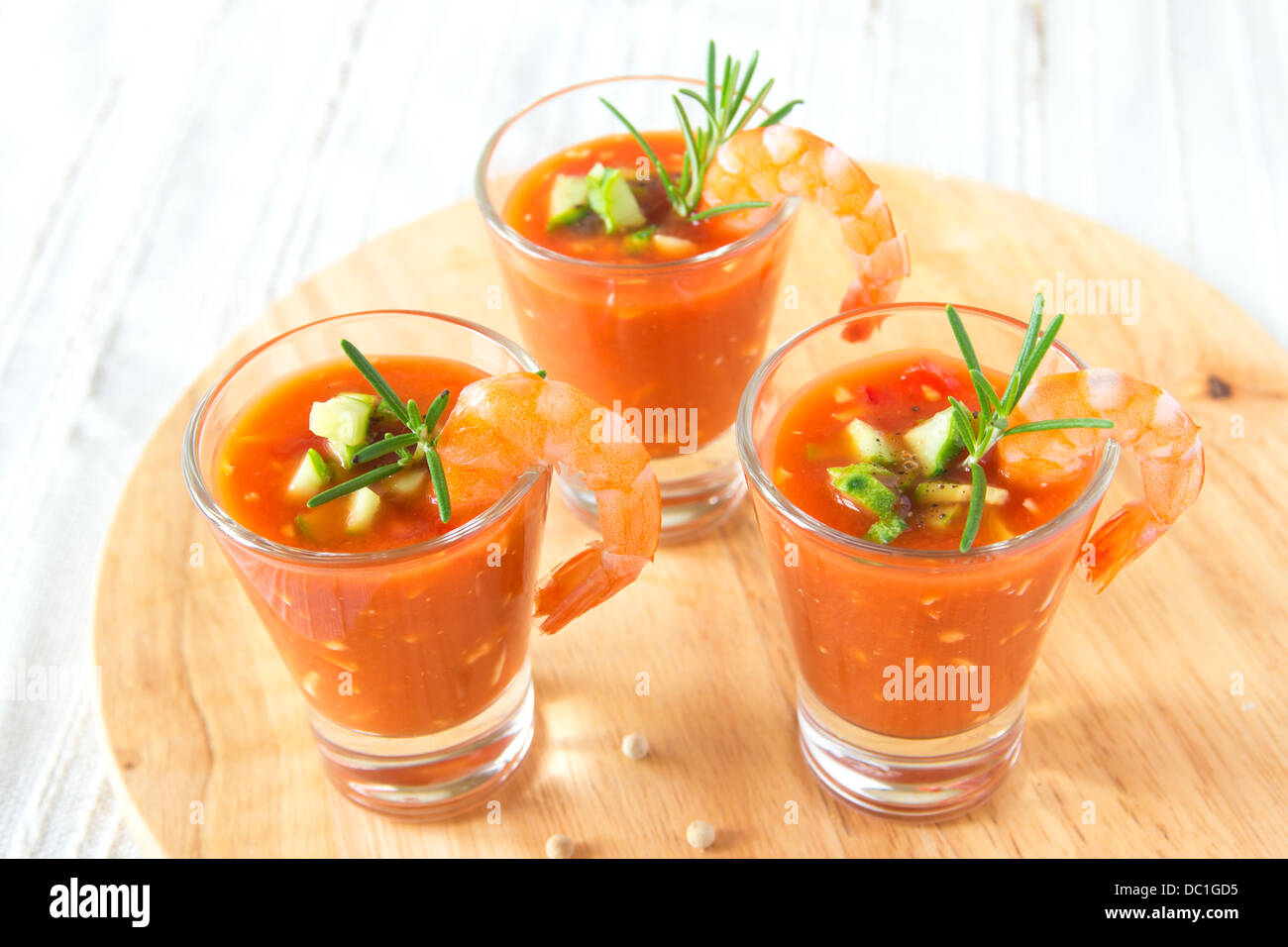 Délicieux froid frais savoureux gaspacho soupe aux tomates en partie lunettes avec les crevettes sur planche de bois, gros plan, horizontal Banque D'Images