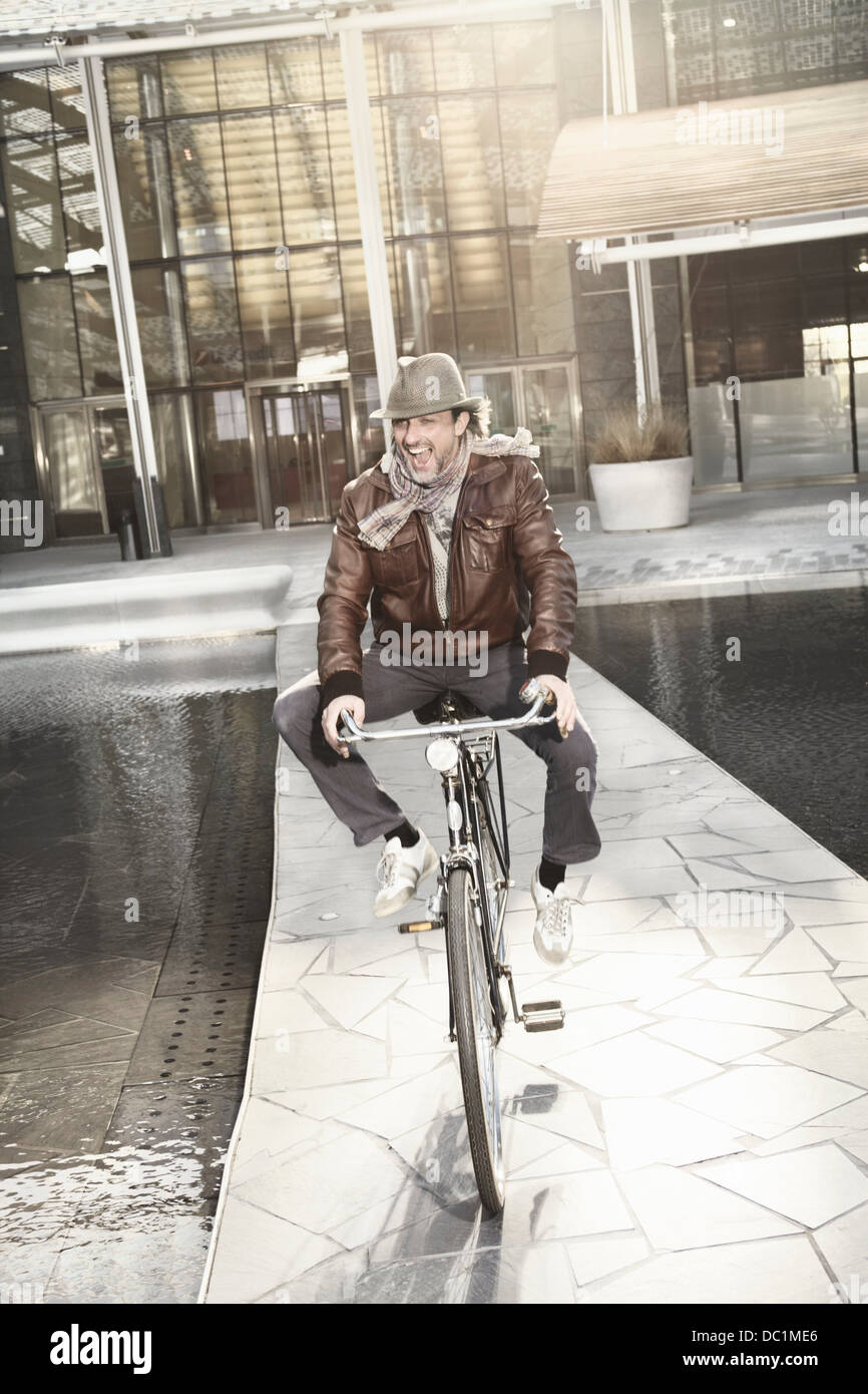 Mid adult man enjoying bike ride en ville Banque D'Images