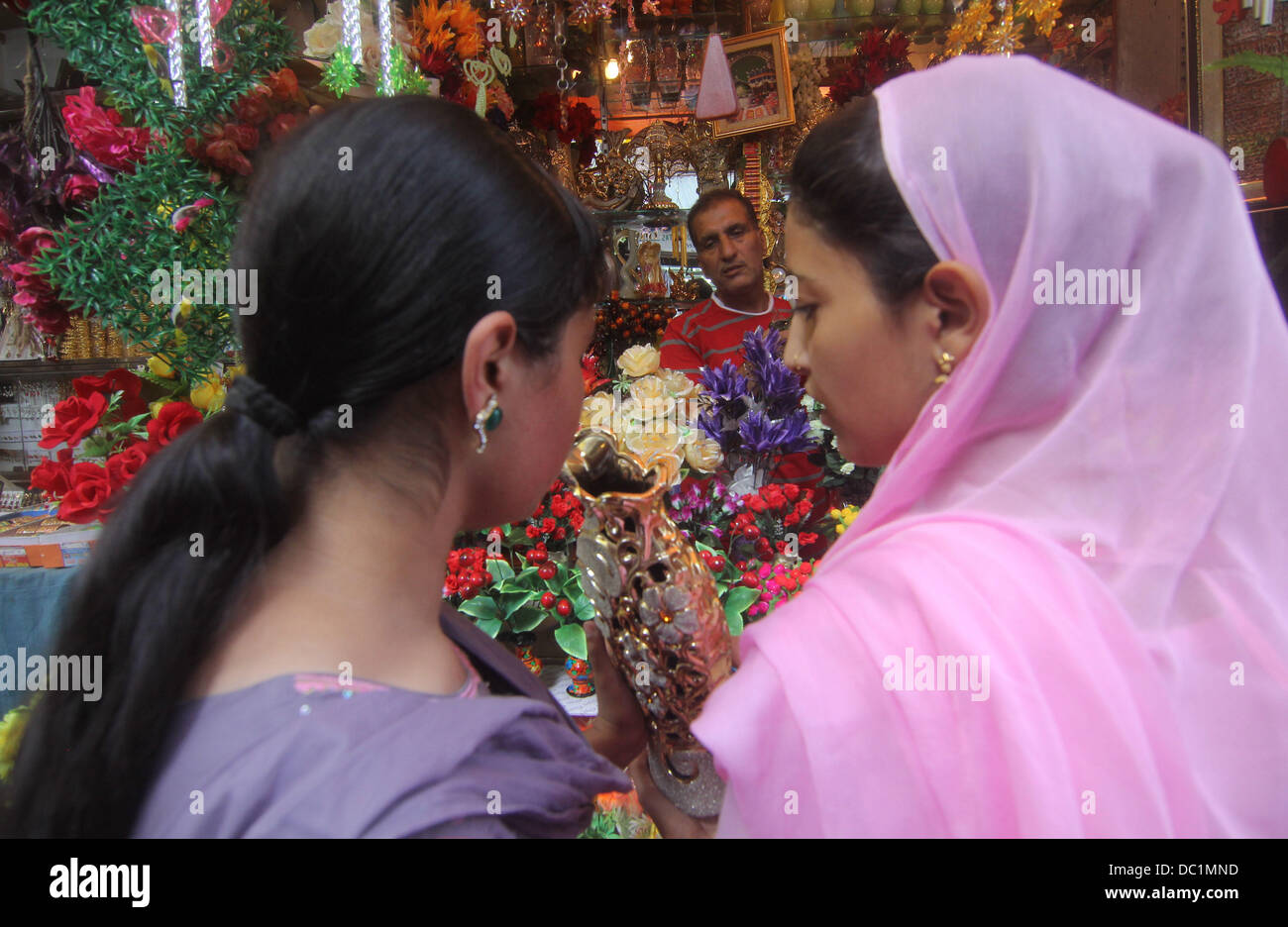 Srinagar, au Cachemire, en Inde. 7e août 2013. Les filles musulmanes du Cachemire l'achat des fleurs au marché central (Lal Chowk) comme ils font leurs achats à venir de l'Eid-ul-Fitir de Srinagar, la capitale d'été du Cachemire indien sur 08/07/2013. Des marchés à travers le monde musulman témoin énorme centre d'urgence dans les derniers jours du Ramadan pour l'Eid-ul-Fitir (Aïd al-Fitr, Eid al Fitr) qui marque la fin du Ramadan. Les célébrations dépendent de l'apparition de Crescent comme calendrier musulman est un calendrier lunaire dans la nature. Comme un cadeau aux sections locales sur l'Eid festival © Altaf Zargar/ZUMAPRESS.com/Alamy Live News Banque D'Images
