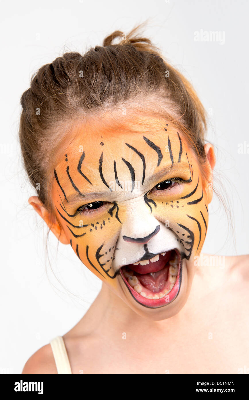 Belle jeune fille au visage peint comme un tigre Banque D'Images