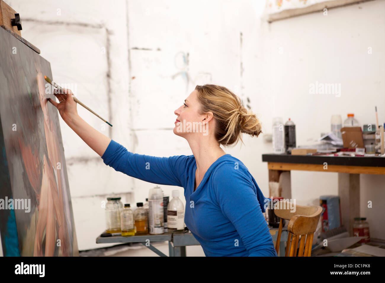 Mid adult woman painting on canvas dans un studio d'artiste Banque D'Images