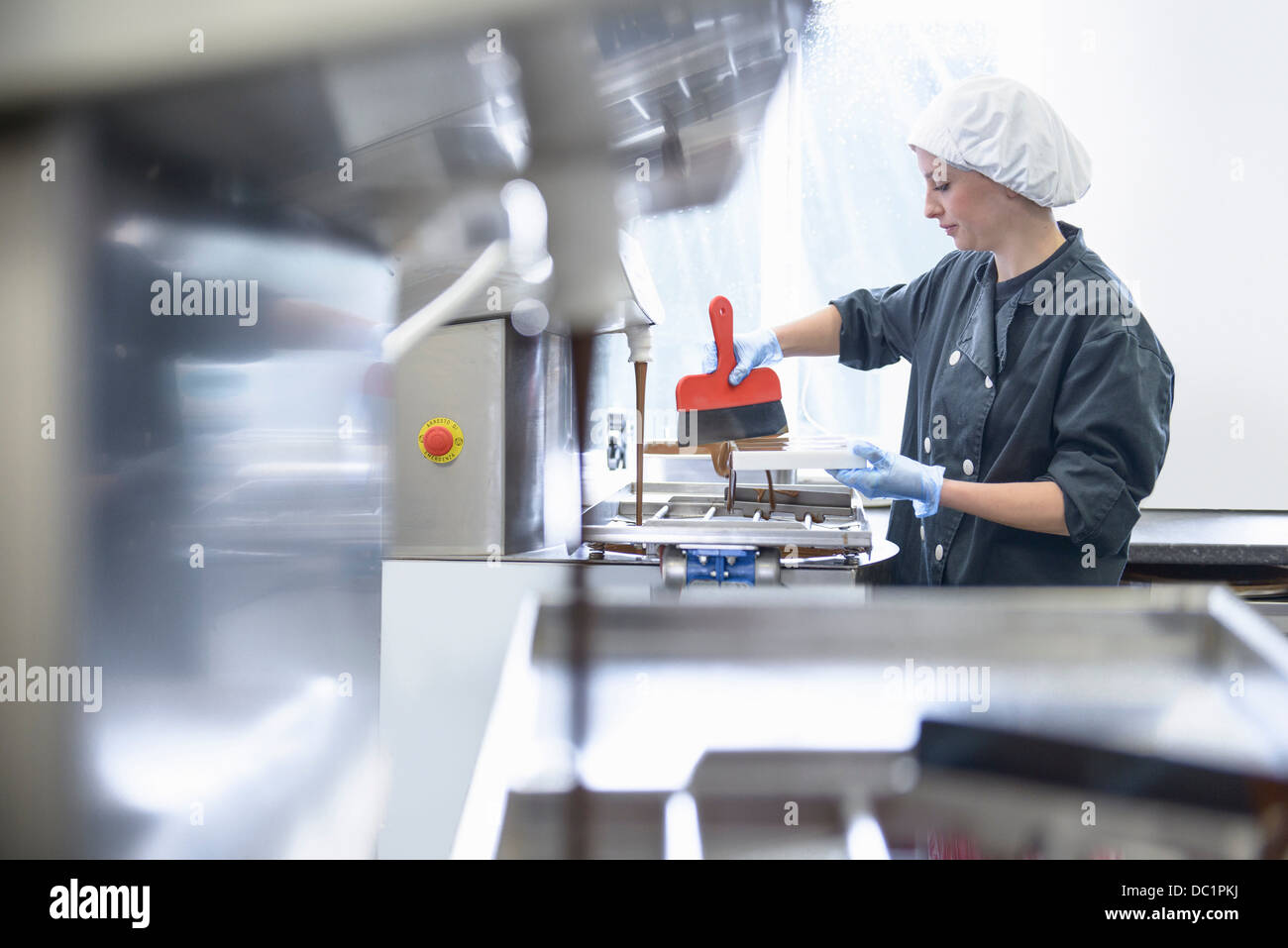 Chocolatier chocolat de lissage dans les moules en sweet factory Banque D'Images