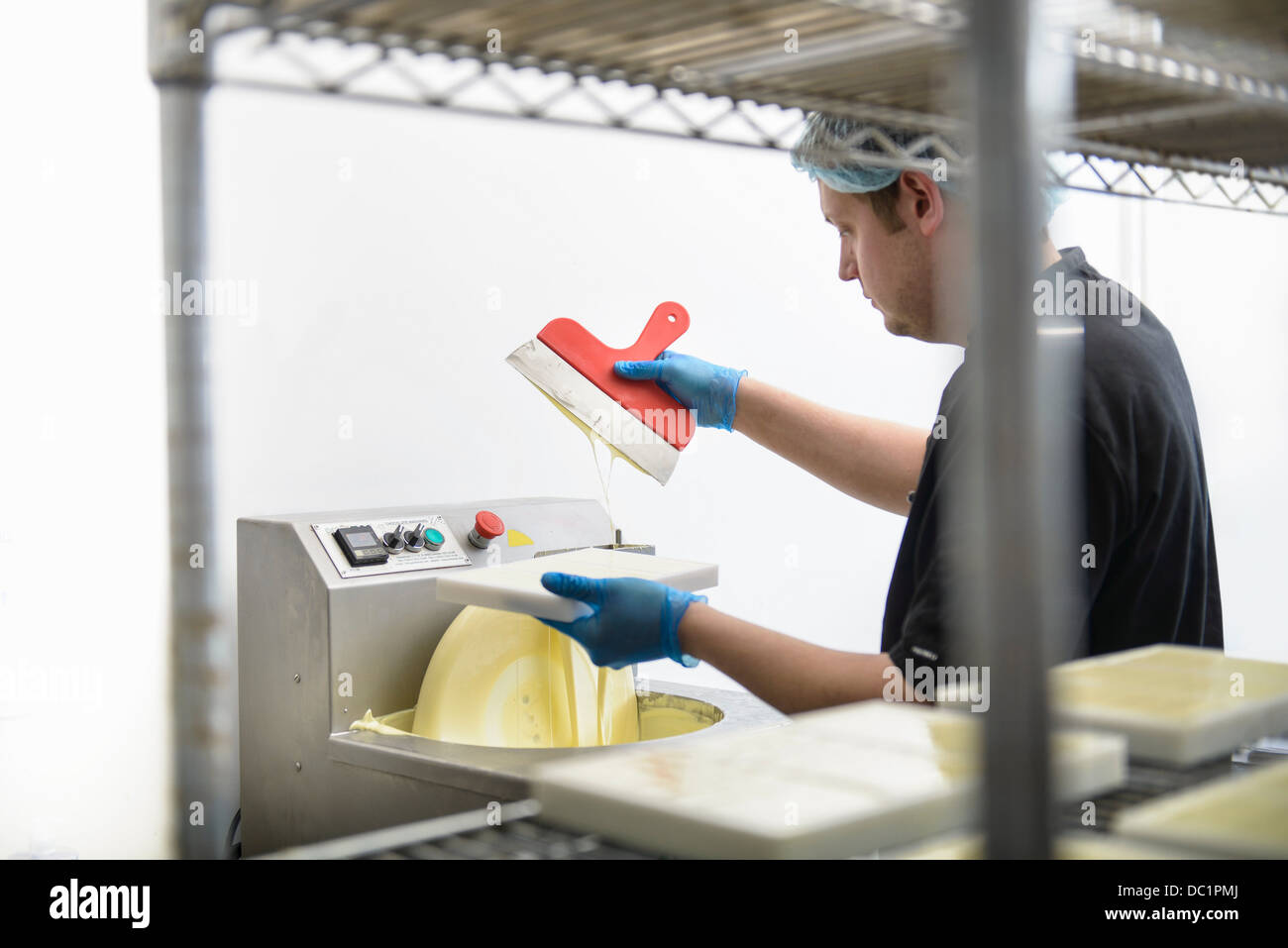Chocolatier chocolat blanc de lissage dans sweet factory Banque D'Images