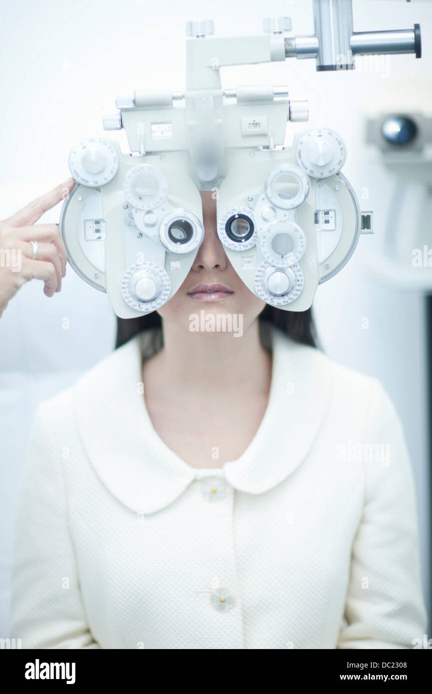 Jeune femme ayant l'essai d'oeil à l'opticien Banque D'Images