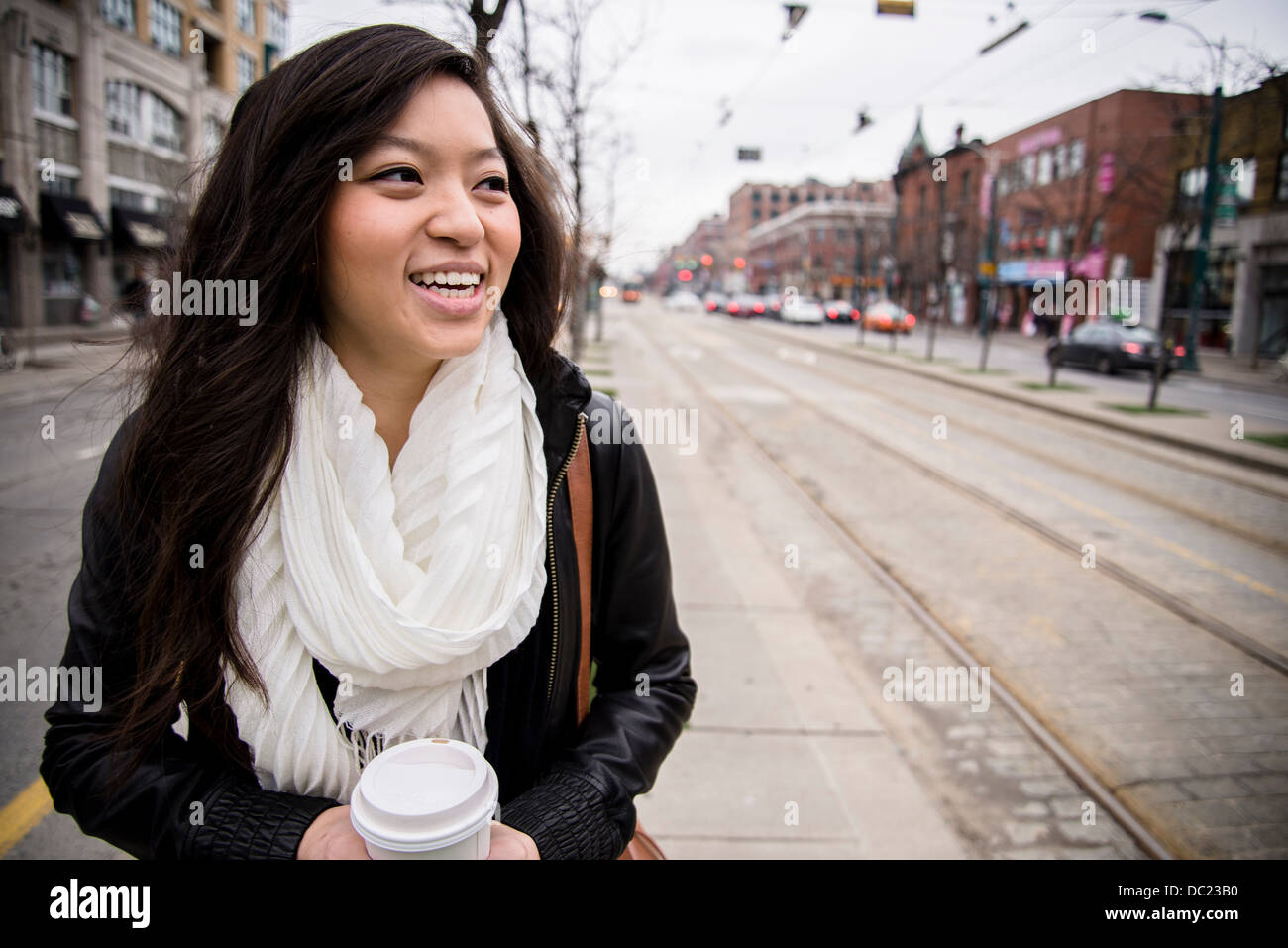 Young woman walking on street en ville, smiling Photo Stock - Alamy