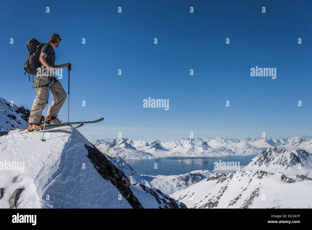 L'homme sur des skis en haut de la montagne dans l'Est du Groenland Banque D'Images