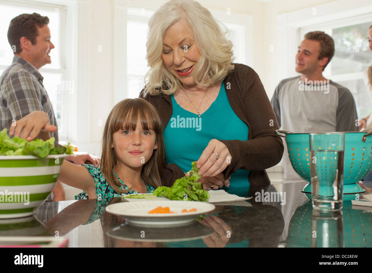 Petite-fille et grand-mère preparing salad Banque D'Images