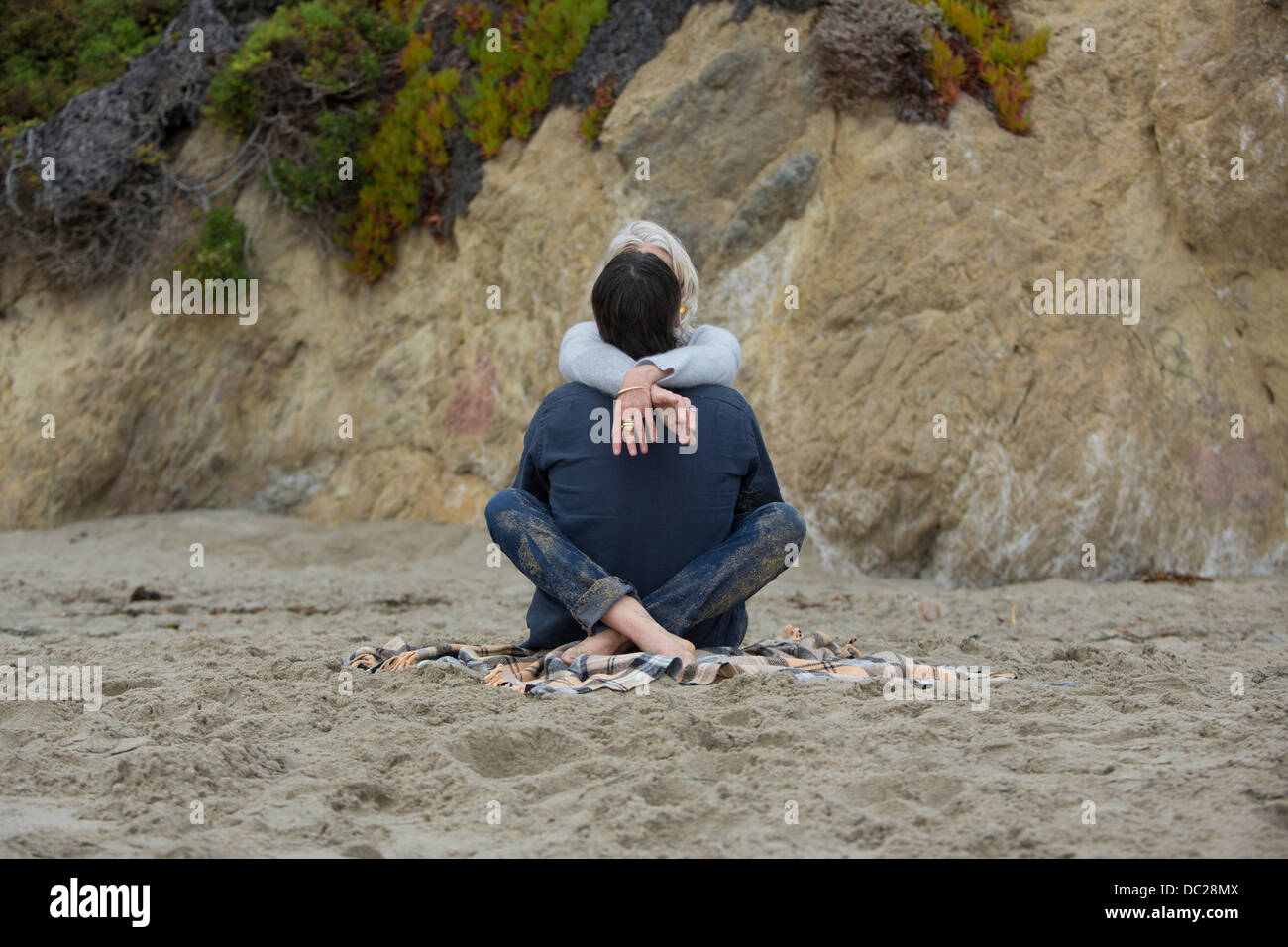 Mature couple sitting on beach cross legged, vue arrière Banque D'Images