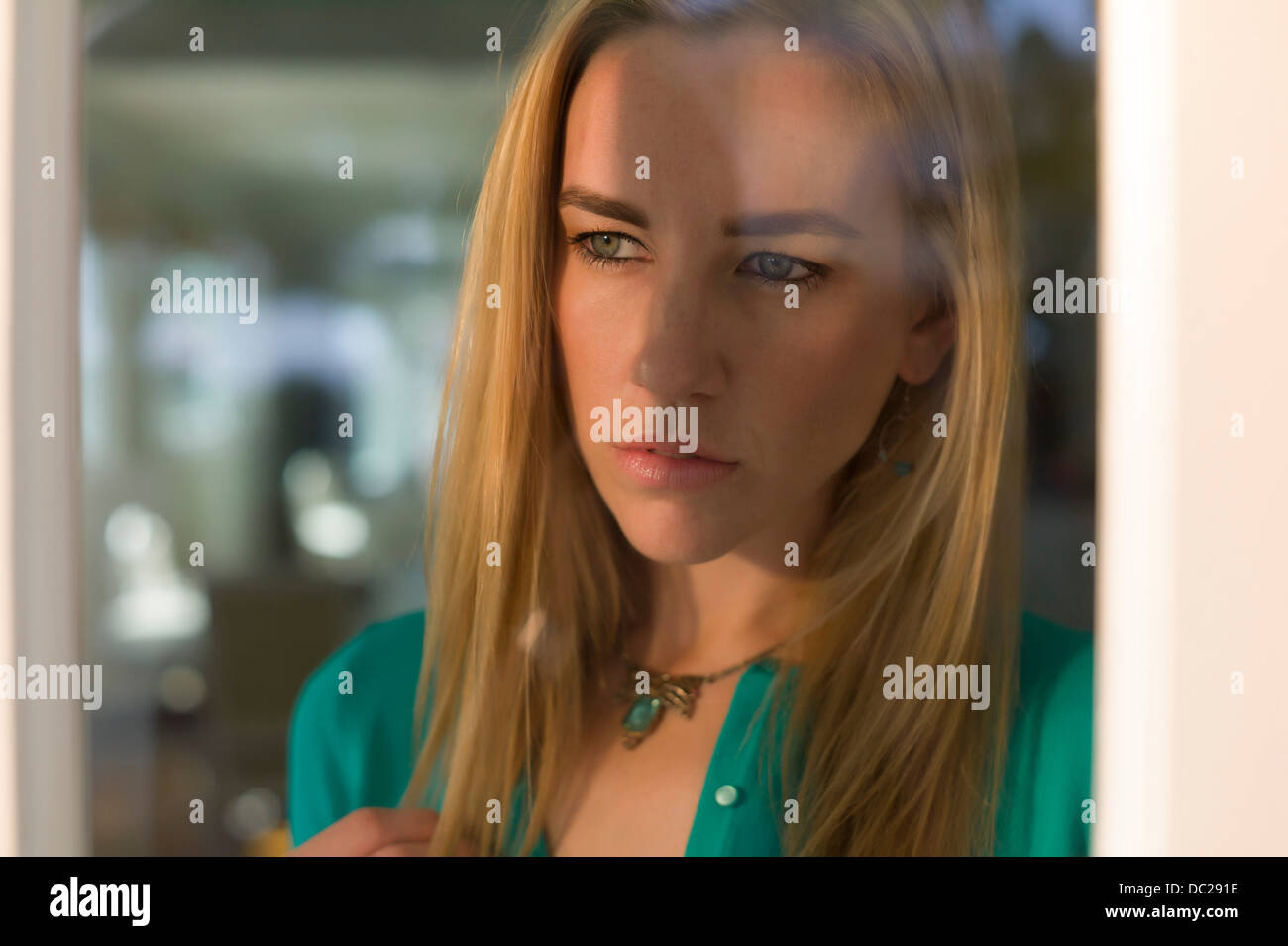 Portrait de jeune femme à la fenêtre de Banque D'Images