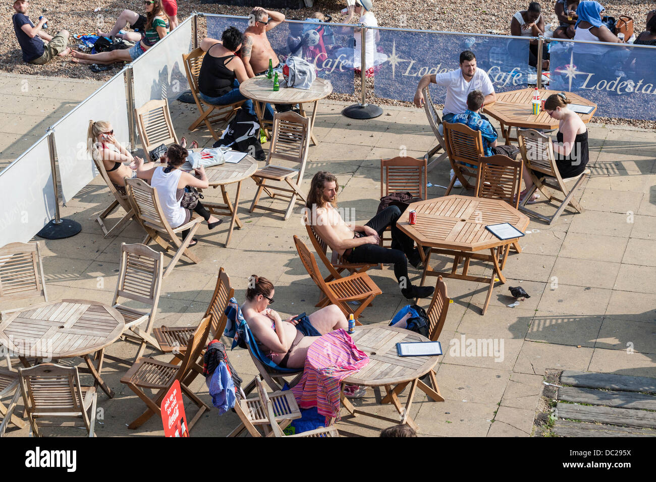 Clients assis sur une terrasse ensoleillée, Brighton, Sussex, Angleterre, Royaume-Uni Banque D'Images