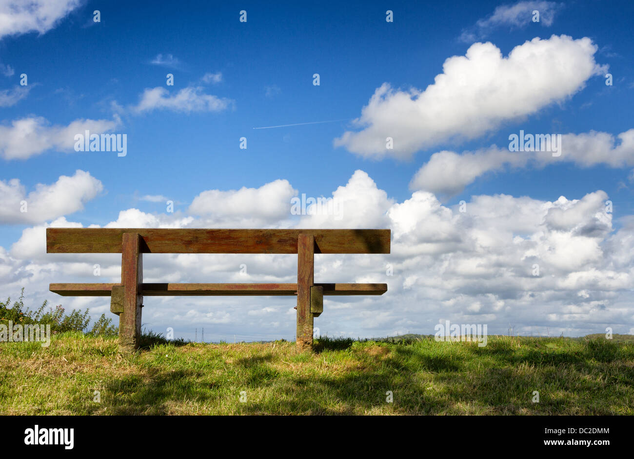 Banc de parc en bois avec bleu ciel nuageux. Banque D'Images