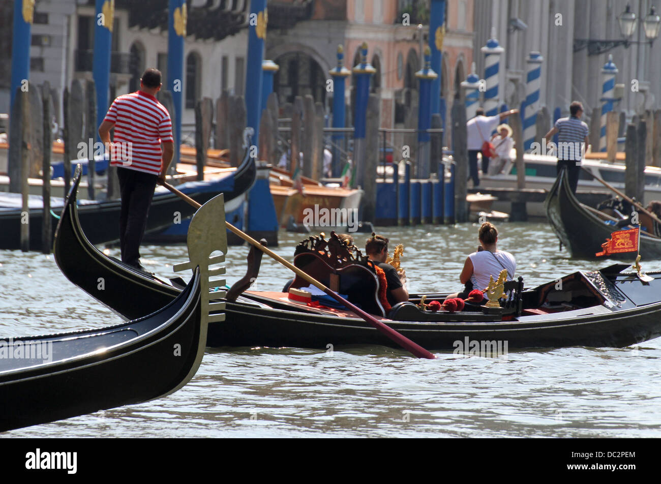 Vénitienne gondolier qualifiés comme il conduit sa gondole sur le Grand canal à Venise Banque D'Images