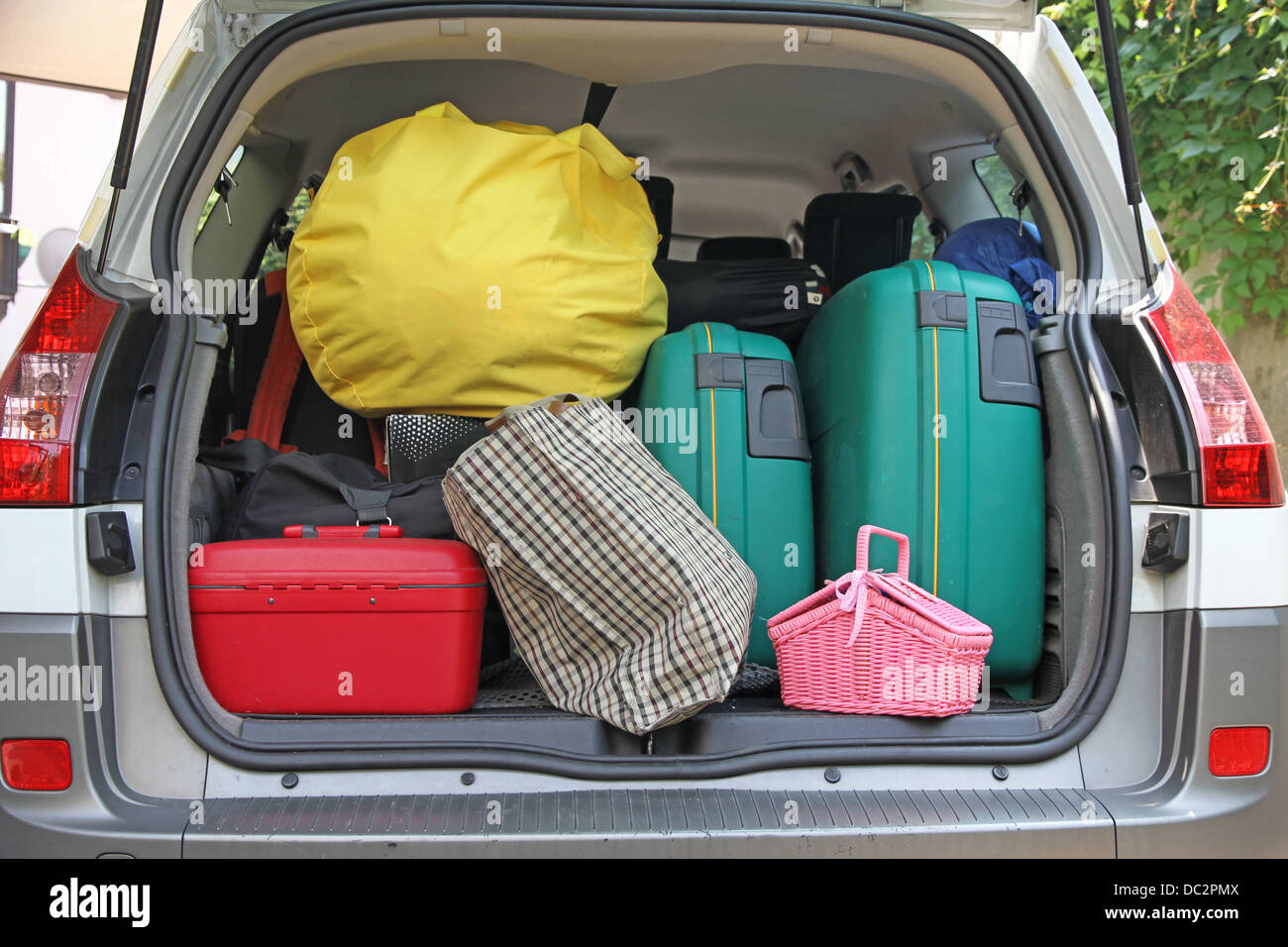 Deux valises vert et de nombreux sacs dans le coffre de la voiture prête à partir pour les vacances Banque D'Images