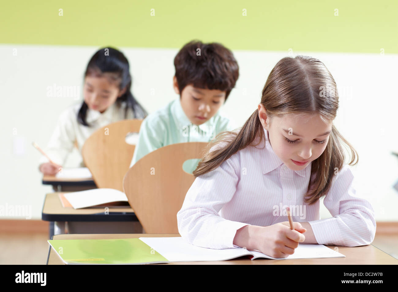 Dans une salle de classe pour les enfants assis dans une ligne Banque D'Images