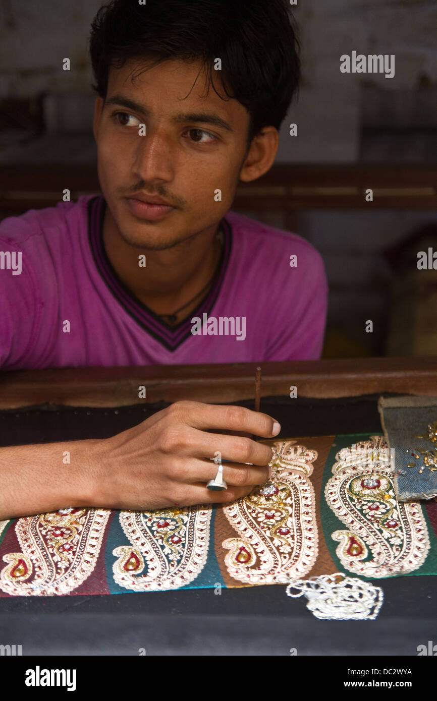 Stiching man beads à sari à Varanasi en Inde Banque D'Images