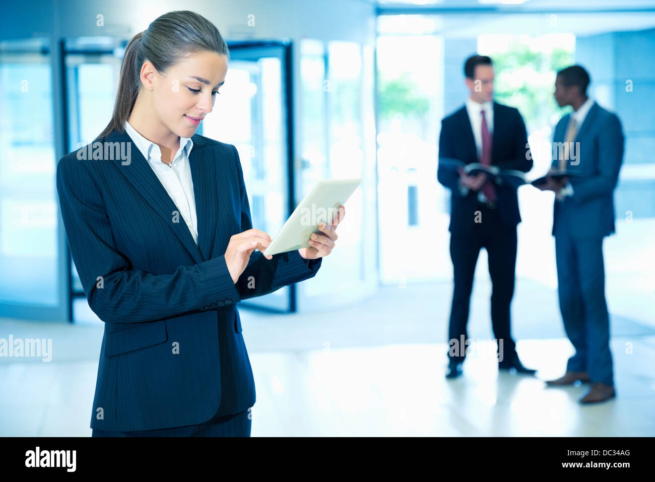 Businesswoman using digital tablet in lobby Banque D'Images