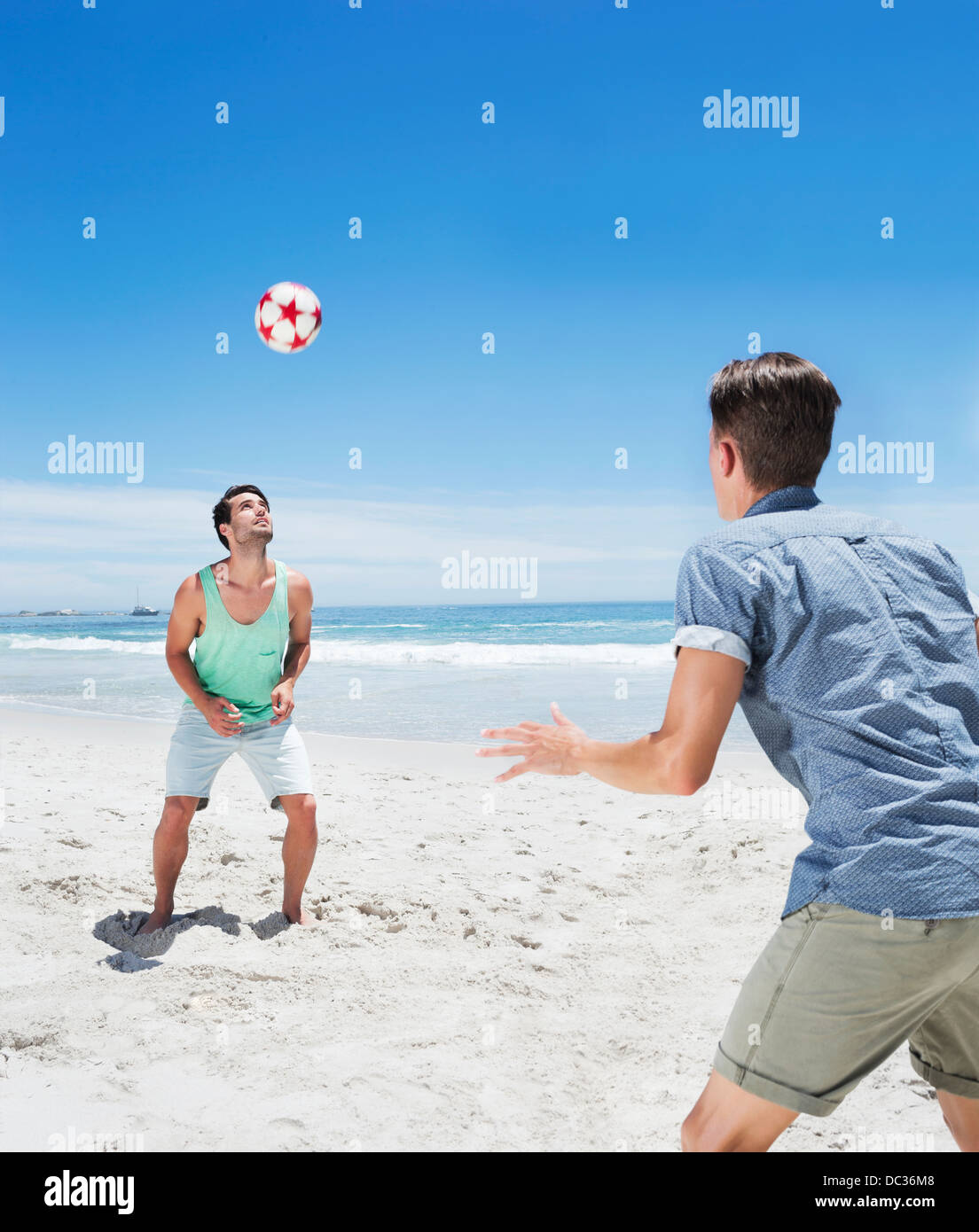 La position de l'homme ballon de soccer on beach Banque D'Images