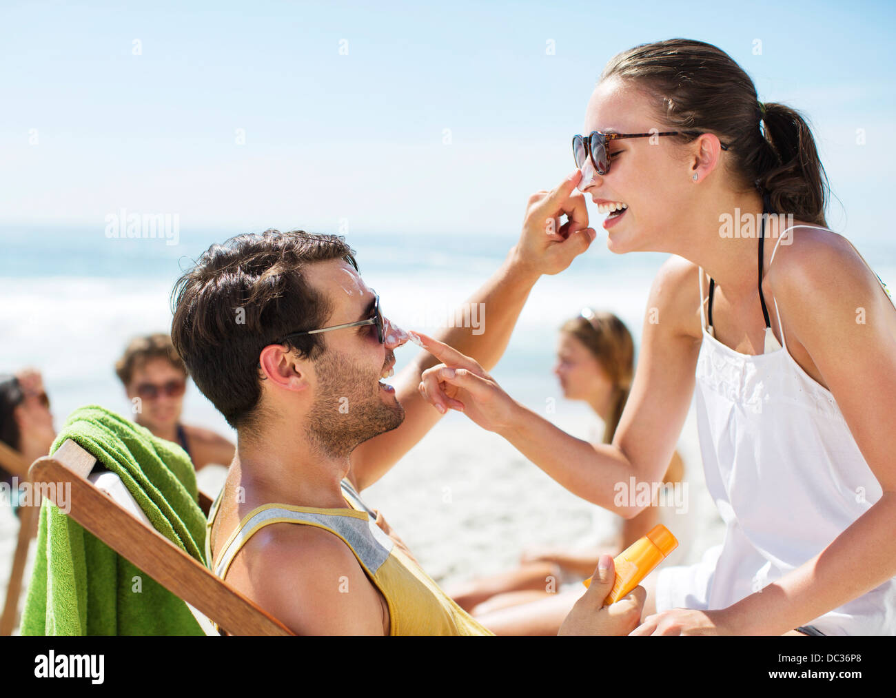 Appliquez un écran solaire à deux par le nez on beach Banque D'Images