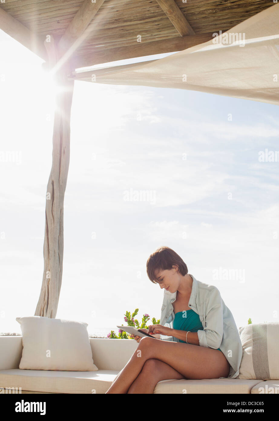 Woman using digital tablet on sunny patio Banque D'Images